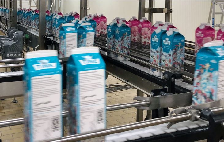 Bildet viser en pakkelinjeprosess med literskartonger med melk.