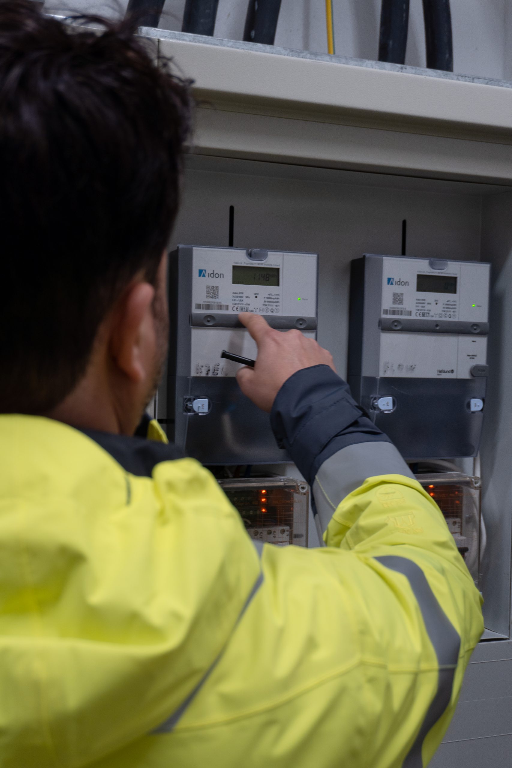 Man in high visibility checking electricity meter